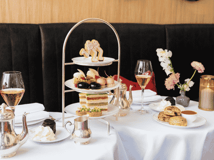 Restaurant Rote Bar mit roten Samtsesseln, weißen Tischdecken, Kristalllüstern und klassischem Interieur im Hotel Sacher