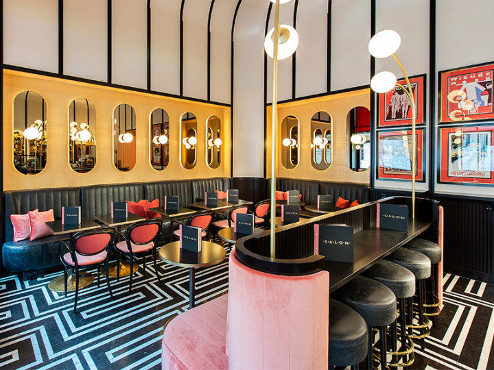 Stylish bar with modern interior, pink velvet, elegant mirrored walls and geometric floor pattern