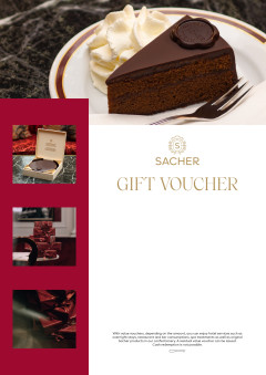 Sacher voucher with slice of Original Sacher-Torte, whipped cream, marble surface, and luxury packaging